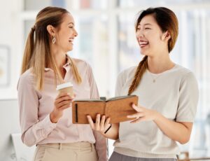Women employee smile and laugh while planning a strategy in a marketing and advertising office. Div